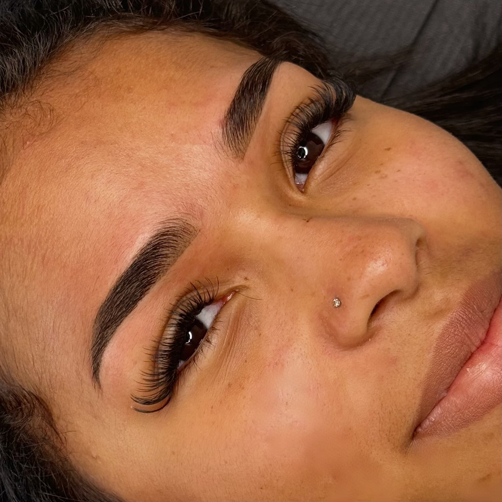 Tatouage des sourcils permanent sur peau mate à Dijon avec microshading intense et tracé parfait.