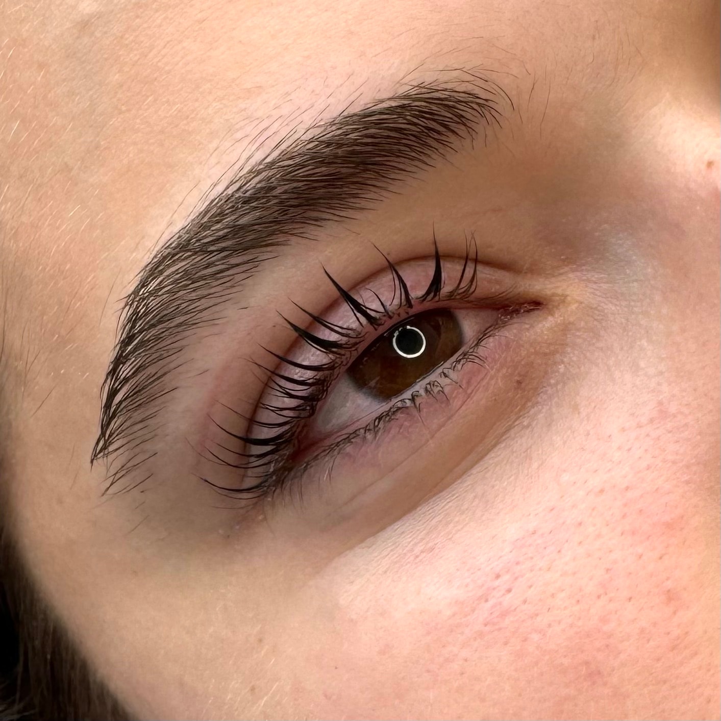 Courbure accentuée sur cliente aux yeux noisette, peau claire et sourcils définis, lash lift à Dijon.